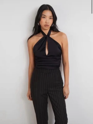 Svart halterneck topp från Gina Tricot - Snygg svart halterneck topp från Gina Tricot med knyt i ryggen och ett litet hål framtill. Helt ny med prislapp kvar! 