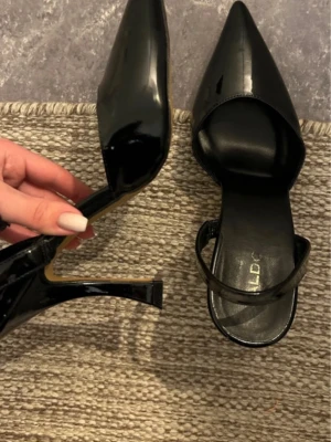 Svarta klackskor från ALDO - Säljer dessa jättejättefina svarta klackskor från ALDO. Skorna är i storlek 37, svarta och glansiga med en spetsig tå. Skorna har en öppen häl, och klacken är ca 8-9 cm höga🤩 Klackskorna är bara använd ett par gånger och har lite svagt skrapmärken på (kolla bilder) men inget som syns jättemycket💘 Skriv gärna om det finns frågor!