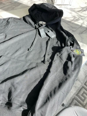 Svart Hoddie med en badge  - Aldrig använd, storlek XL men sitter som M/L, ta gärna instabox 