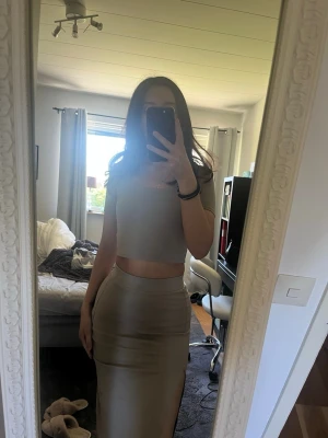 Beige bodyset med crop top och kjol - Ett beige set med en kortärmad crop top och en figurnära lång kjol med slits.