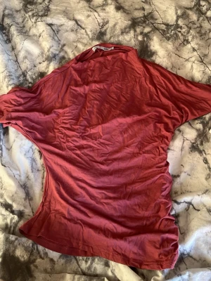 Röd t-shirt från 157 i bomull - En enkel röd t-shirt från 157 i mjuk bomull. Modellen är klassisk med korta ärmar och rund halsringning. Perfekt för en avslappnad och stilren look.