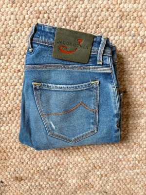 Jacob Cohen 622 slim fit  - Säljer dessa riktigt feta Jacob Cohen jeans i modellen 622👌. Jeansen har snygga orginalslitningar gjorda i fabrik, vilket gör dom väldigt unika och sällsynta🙌. Nypris är 6000+ eftersom det är en unik design🤝. Storlek=W31, Skick: 9,5/10🌟. Hör gärna av er vid frågor eller funderingar👍