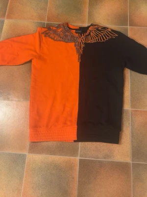 Marcelo Burlon tröja långarmad  - En svart Marcelo Burlon tröja i svart och orange. Storlek S. Skriv för intresse.