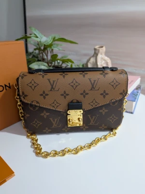 Iouis vuitton pochette métid - Tidlös elegans ✨ Iouis Vuitton Pochette Métis East-West i det ikoniska Monogram Reverse-mönstret. En perfekt balans mellan klassiskt och modernt. Den ultimata väskan för både vardag och fest! 👜