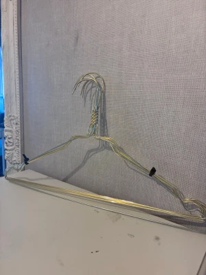 4 metallgalgar i silverfärg & en i guldfärg - Säljer ett gäng klassiska galgar i metall med 4st i silverfärg och en i guldfärg. Perfekta för att hänga upp kläder i garderoben eller på klädställning. Galgarna har en enkel och stilren design med tvinnad krok och är lätta att använda.