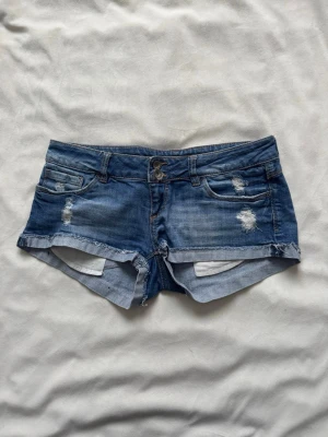 Lågmidjade jeansshorts  - Blå lågmidjade jeansshorts ifrån Tally weijl i storlek 38! 
