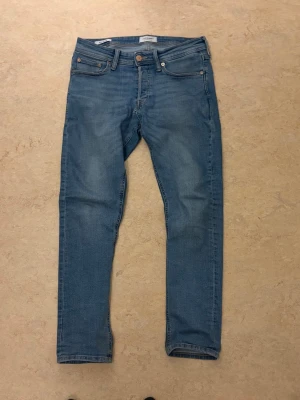 Ljusblå slim fit jeans - Snygga ljusblå slim fit jeans med klassisk femficksdesign och normal midja. Jeansen har en lätt tvättad look och raka ben. Perfekta för en avslappnad stil och passar till det mesta i garderoben. Vid mer info kontakta gärna! ABS! Pris går att diskutera! Och det finns ett litet hål i byxan och det går enkelt att sy, och det är därför priset är nersatt. 