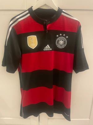 Tyskland 14/15 fotbollströja - Tyskland bortställ 14/15. I bra skick utan några defekter. Den är äkta. Sparsamt använd. Storlek M