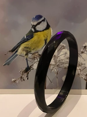 Svart facetterat armband i plast - Snyggt svart armband med facetterad yta som ger en cool glans. Tillverkat i plast och har en enkel, rund form som passar till många olika stilar. Perfekt accessoar för dig som gillar minimalistiska smycken med lite edge. 