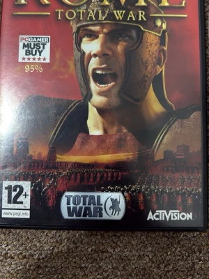 Rome: Total War PC – Komplett 3 CD, originalbox + manual/karta - Säljer mitt Rome: Total War-spel till PC. Detta är en komplett fysisk utgåva med: 	•	Alla 3 CD-skivor 	•	Originalbox 	•	Manual och karta (instruktionsblad/folder)  Spelet är från originalutgåvan och fungerar på äldre PC-system. Box och manual är i bra skick, skivorna är testade och fungerar.Skickas som mellanstorleks paket för att skydda boxen.  💰 Pris: 200 kr (eller bud)