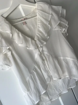 Vit volangblus från Nelly - Jätte sött vitt blus som endast är används en gång då jag råkade köpa i för liten storlek💗skriv för fler bilder eller annat