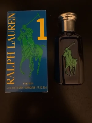Ralph Lauren Big Pony 1 EdT 50ml - Fräsch herrparfym från Ralph Lauren, Big Pony 1. Flaskan är blå med silverfärgad kork och har en grön polospelare på framsidan. Kommer i en snygg blå kartong med gult och grönt tryck. Volymen är 50 ml Eau de Toilette Spray.
