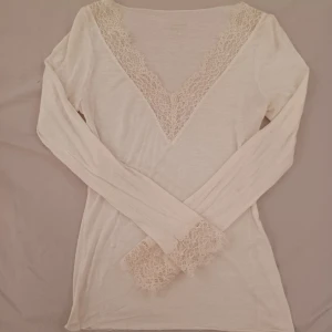 Vit intimissimi  - Säljer en vit intimissimi. Sydde två hål och har tappat lite färg/ tyg på ena armen och har även en liten prick, antagligen från smink. Kommer inte till användning längre, skulle även säga att den blivit lite missfärgad så den är mer krämvit 💕 Pris går att diskutera!🫰🏻