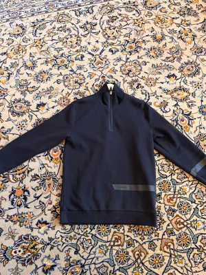 Mörkblå half-zip tröja från BOSS - Säljer min half zip för jag inte använder den längre den har använts ett få tal gånger och är i bra skick. Den är köpte i  Hugo boss affär och köptes för 1099kr ny.  mannen på bilden är 185cm och väger 78kg.  