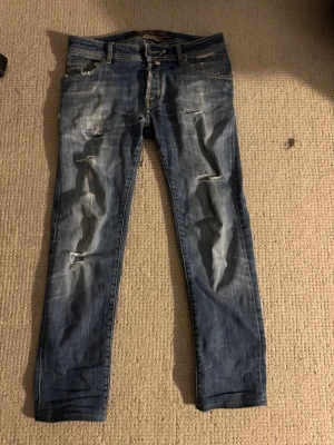 Jacob cohen jeans  - Ett par asfeta Jacob cohen jeans med snygg fade och fina slitningar, litet hål vid skrevet på bild 4 men annars mycket bra skick. De kostar endast 449kr ! Nypris runt 3000-5000kr