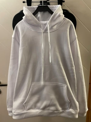 Vit hoodie - Mjuk och snygg vit hoodie med 100% polyester i storlek Large med huva och praktisk magficka. Skön passform och stilren design som passar lika bra till vardags som till avslappnade tillfällen. En bekväm favorit i garderoben.✨