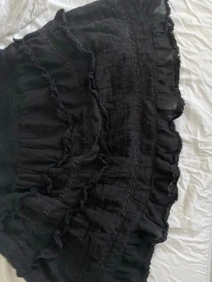 Svart volangkjol med resårmidja - Supersöt svart kortkjol med flera volanglager 