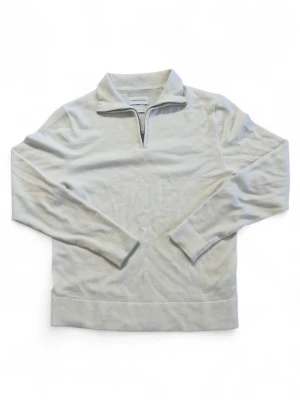 Beige långärmad tröja med krage - Stilren beige långärmad tröja från These Glory Days med klassisk krage och halv dragkedja framtill. Tröjan är tillverkad i mjukt material och har breda muddar vid ärmslut och nederkant. Perfekt för en avslappnad look.