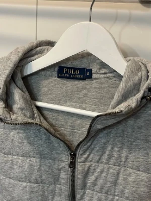 Ralph Lauren cardigan  - Snygg grå hoodie från Polo Ralph Lauren med dragkedja framtill och quiltad design. Bra skick och passar perfekt till våren! Skriv vid funderingar! Passa på vid fri frakt!!
