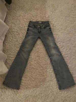 Bootcut jeans i ljusblå denim från Nelly - Säljer ett par ljusblå bootcut jeans från Nelly. Jeansen är uppsydda 3 cm men finns möjlighet att sy ner för ytterligare 40 kr ! Jeansen passar mig perfekt på längden som är 161 (uppsydda). Jätte fina jeans,  men kom tyvärr aldrig till användning. 🥹