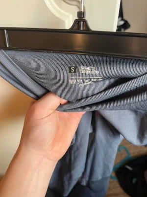 Grå seamless leggings med hög midja - Snygga grå seamless leggings med hög midja och ribbade detaljer. Tillverkade i 92% nylon och 8% spandex för en stretchig och bekväm passform. Perfekta för träning eller chill dagar. Tight modell som formar sig efter kroppen.