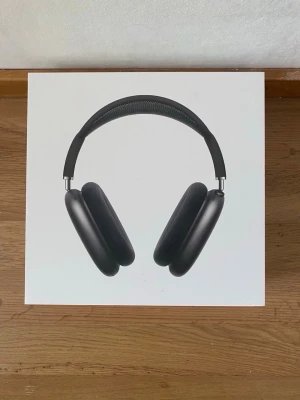 Apple AirPods Max Svart - Snygga Apple AirPods Max i svart med over-ear design. Tillverkade i aluminium och rostfritt stål med mjuka öronkuddar i mesh-tyg för extra komfort. Levereras med originalförpackning, laddkabel och smart case.