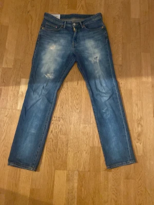 Blå regular fit jeans  - Säljer ett par blå regular fit jeans från H&M i storleken W30 och L32. Har gjort fadesen och hålen själv. Tyckte dom blev riktigt feta.