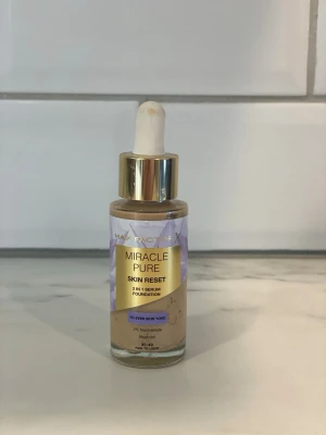Max Factor Miracle Pure Foundation - Max Factor Miracle Pure Skin Reset Foundation i nyansen 30-40 Fair to Light. Flytande foundation med pipettapplikator och guldigt lock. Ger en naturlig finish och innehåller 2% niacinamid och bakuchiol för extra hudvård.