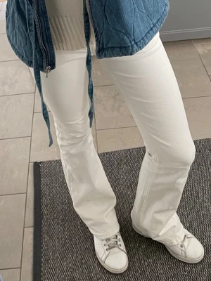 Vita bootcut jeans - Säljer ett par vita bootcut jeans med låg midja och klassisk femficksdesign. Jeansen har en snygg utsvängd passform som ger en retrovibe och är perfekta att styla med sneakers eller boots. Materialet känns mjukt och stretchigt för extra komfort. 💞💞