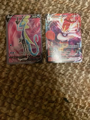 Pokémonkort Inteleon V och Cinderace VMAX - Två samlarkort från Pokémon, Inteleon V och Cinderace VMAX. Båda korten har färgstarka motiv med holografiska effekter och klassisk Pokémon-design på baksidan. Perfekt för dig som vill utöka din samling med coola och unika kort.