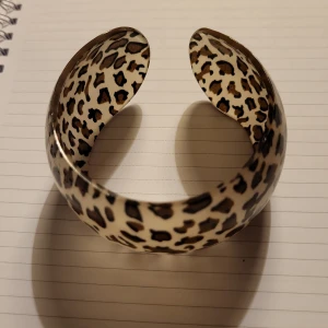 Bred leopardmönstrad armbandsbåge - .“Stilrena och trendiga breda C-formade armband i resin med elegant leopardmönster och unika, djärva geometriska detaljer – ett iögonfallande smycke som ger din stil en modern och exklusiv touch.”