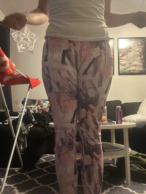 Färgglada tränings leggings - Säljer ett par leggings med ett coolt abstrakt mönster i lila, rosa och svart. De har hög midja och sitter tight längs benen. Perfekta för dig som gillar att sticka ut med din stil!