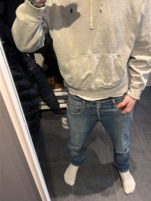 Grå hoodie från Polo Ralph Lauren - Snygg grå hoodie från Polo Ralph Lauren med klassisk huva och dragsko. Har en stor magficka och den ikoniska lilla loggan broderad på bröstet. Tillverkad i mjuk bomullsblandning som är skön att bära. Perfekt för en avslappnad och stilren look.