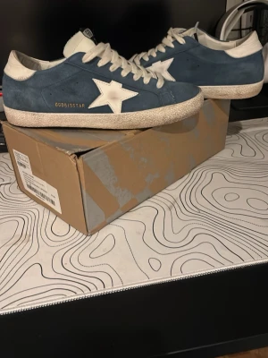 Blåa Golden goos skor - Nu är det tyvvär dags att sälja mina älskade Golden goose skor… Dem är omhändertagna väldigt bra och är sparsamt använda, knappt använda då jag köpte dem innan vinter och det har snöat/regnat så mycket så jag inte har kunnat använda dem, och nu har det växt ur. Skulle säga att dem är i fint skick och väldigt fina skor med blå mocka. Pris 2999 kan prutas ner. Fler frågor? Kom privat. Tyvvär inget kvitto men kan garantera att den är riktiga