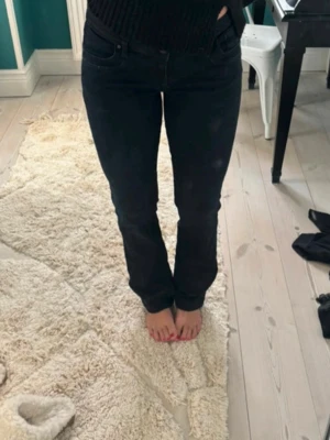 Svarta raka jeans - Säljer ett par svarta jeans med rak passform och klassisk femficksdesign. Jeansen har normal midja och är tillverkade i ett stretchigt denimtyg som sitter snyggt på kroppen. Perfekta till en avslappnad stil.
