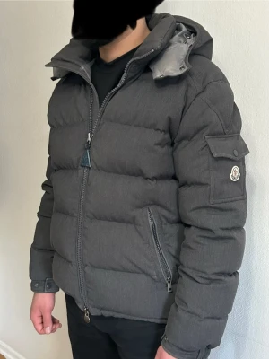 Moncler montgenevre  - Moncler Montgenevre – Grå – Strl 4 (L) – Väldigt fint skick  Säljer min Moncler Montgenevre, en av Monclers mest eftertraktade modeller. Stilren grå färg som passar till allt och perfekt för vintern tack vare äkta dun som gör den väldigt varm men samtidigt lätt.  • Storlek: 4 (passar L) • Färg: Grå • Skick: Väldigt fint skick • Avtagbar huva • Moncler-logga på armen • Flera fickor med dragkedja  Först till kvar  Endast seriösa köpare