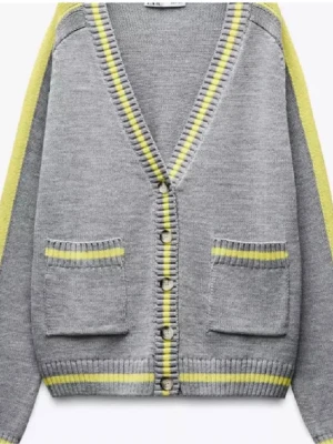 Grå kofta med gula detaljer - Snygg grå kofta med knappar framtill och gula samt vita ränder längs kanterna och på fickorna. Koftan har två framfickor och ribbstickade muddar. Perfekt för dig som gillar en avslappnad men trendig stil.