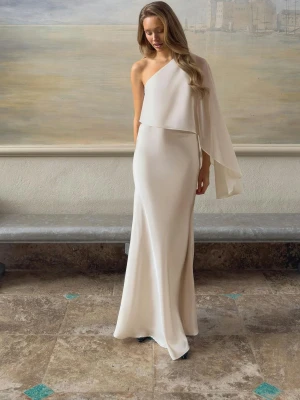 Vit oneshoulder långklänning - Elegant vit långklänning i oneshoulder-modell med svepande tygdetalj över ena armen. Dragkedja i sidan, otroligt fin!