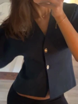 Stickad Zara topp - Topp ifrån Zara i stickat material med guldknappar i storlek m, passar även s. Mycket bra skick