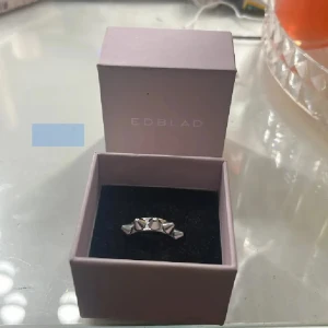Edblad ring - Säljer min ring från Edblad i blankt silverfärgat material med konformade nitar runt hela ringen. Snygg och populär. Kommer i original ask och är i 16.00. Inte nå mycket använd! Nypris: 349kr!☺️