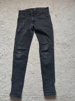 Svarta skinny jeans från Replay - Snygga svarta skinny jeans från Replay med klassisk femficksdesign och diskreta slitningar. 