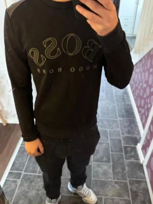 Svart sweatshirt från Hugo Boss - Sitter helt okej på mig som är 170, lite hårig men löser de innan ja skickar