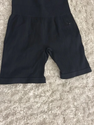 Svarta ribbade cykelshorts - Snygga svarta cykelshorts med ribbad struktur och hög midja. Perfekta för en sportig look eller att styla med oversized t-shirt. Stretchigt material som sitter bekvämt och följer kroppen.