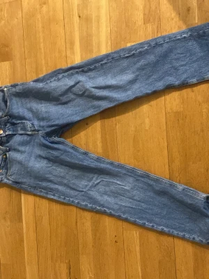 Blå raka jeans från Jack & Jones - Säljer ett par klassiska blå jeans från Jack & Jones med rak passform och normal midja. Jeansen har fem fickor, knappgylf och är tillverkade i slitstark denim. Perfekta för en avslappnad och tidlös stil. Pris kan diskuteras.