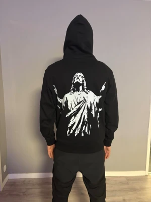 Svart hoodie med Jesus-tryck(ThruChrist) - ThruChrist helt ny kofta limiterade antal size M unisex ThruChrist loggan vid bröstet med Jesus bilden bakom ryggen     Instagram:ThruChristCo