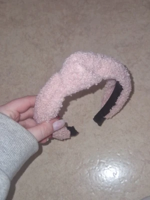 Diadem med struktur - Säljer ett gulligt rosa diadem med fluffig, mjuk teddystruktur. Diademet är lite vadderat och har en bred form som ger en trendig look. Insidan är svart för extra kontrast. Perfekt accessoar för att lyfta din outfit.