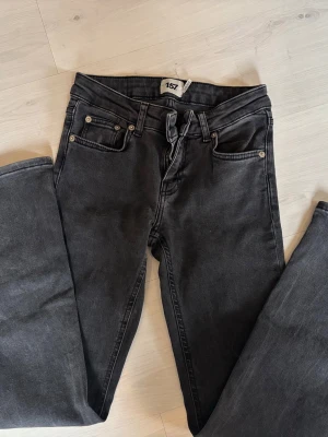 Svarta bootcut jeans från 157 - Snygga svarta bootcut jeans från 157 med låg midja och klassisk femficksdesign. Jeansen har en cool tvättad look och är tillverkade i mjukt denimtyg som sitter skönt. Perfekta för dig som gillar en avslappnad men trendig stil.