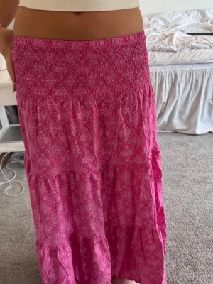 Rosa långkjol med mönster - Säljer en super söt rosa lång kjol med mönster🩷🩷står ingen storlek men gissar på s/xs!