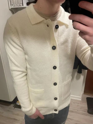 Vit stickad cardigan - Otroligt snygg vit stickad cardigan. Passar perfekt till det kalla vädret. Modellen är 180cn, 75kg. Priset kan såklart diskuteras!