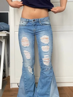 Lågmidjade jeans med slitningar  - Säljer dessa lågmidjade jeans med slitningar på benen. Jeansen är omsydda till bootcut och midjemått 37 cm innerbenslängd 73 cm. Kontakta mig gärna privat vid frågor eller liknande 💕💕